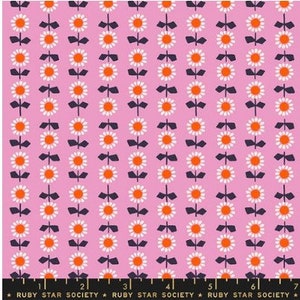 May include: Pink fabric with a repeating pattern of white flowers with orange centers and black stems. The flowers are arranged in vertical rows.