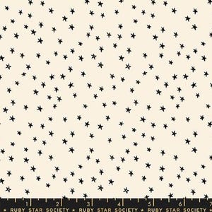 May include: Cream-colored fabric with a scattered pattern of black star shapes. The stars vary in size and are evenly distributed across the surface. The fabric has a subtle texture and a soft, neutral color palette.