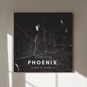 May include: A black and white map of Phoenix, Arizona, with the city name and coordinates printed in white. The map shows the city's streets and major landmarks.