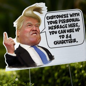 May include: A yard sign featuring a caricature of a man in a suit and tie, giving a thumbs-up. The sign includes the text: "CUSTOMIZE WITH YOUR PERSONAL MESSAGE HERE. YOU CAN USE UP TO 84 CHARCTERS."