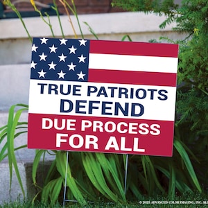 May include: A rectangular yard sign with the American flag design in the upper portion. The sign reads "TRUE PATRIOTS DEFEND DUE PROCESS FOR ALL" in bold, white letters against a red background. The sign is supported by metal stakes.