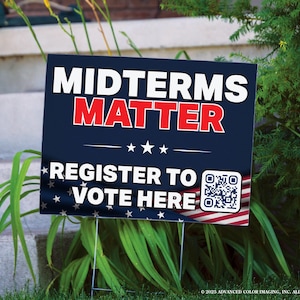 May include: A rectangular yard sign with a dark blue background featuring the white text MIDTERMS and red text MATTER. Below, white text reads REGISTER TO VOTE HERE next to a QR code. The bottom edge displays a red, white, and blue flag pattern.