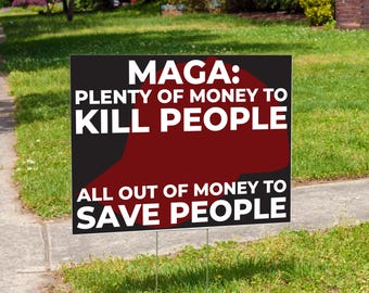 May include: A black yard sign with white text that reads "MAGA: PLENTY OF MONEY TO KILL PEOPLE ALL OUT OF MONEY TO SAVE PEOPLE." A red shape is in the center of the sign. The sign is in a grassy yard.