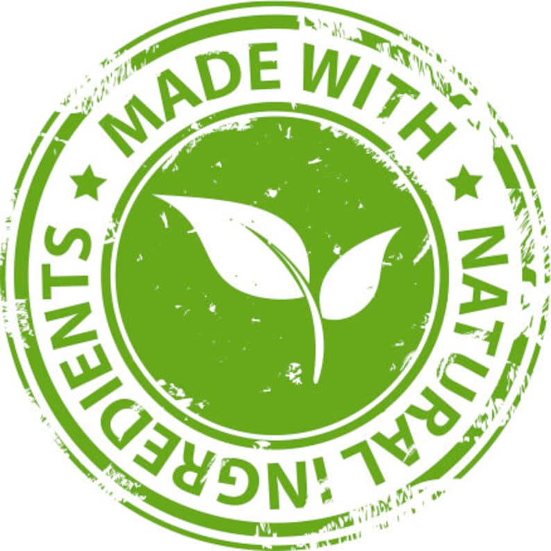 May include: A green circular stamp with the words "MADE WITH NATURAL INGREDIENTS" encircling a central image of two leaves. The stamp has a distressed, worn appearance, suggesting a vintage or handcrafted aesthetic.