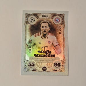 May include: A Topps football trading card with a player in a red and white jersey. The card features the text "Magic Memories" and player statistics. The card has a silver and gold design with the Topps logo.