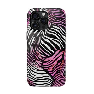 K&ouml;nnte beinhalten: Eine Smartphone-H&uuml;lle mit einem auff&auml;lligen Zebrastreifenmuster in Schwarz, Wei&szlig; und Pink. Die H&uuml;lle hat eine gl&auml;nzende Oberfl&auml;che und eine rechteckige Form mit abgerundeten Ecken. Die Kameralinsen sind oben sichtbar.