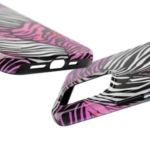 K&ouml;nnte beinhalten: Zwei schwarze Handyh&uuml;llen mit einem Zebrastreifenmuster in Wei&szlig; und Pink. Die H&uuml;llen haben eine gl&auml;nzende Oberfl&auml;che und einen schwarzen Rand. Das Design wiederholt sich auf beiden H&uuml;llen, wobei eine H&uuml;lle teilweise sichtbar ist.