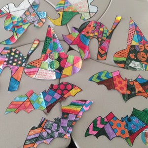 May include: A collection of colorful paper cutouts of bats, witches' hats, and ghosts. Each cutout is decorated with a patchwork design of different colors and patterns, including polka dots, stripes, and geometric shapes.