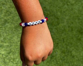 Una pulsera de cuentas con nombre personalizado, rojo, blanco y azul