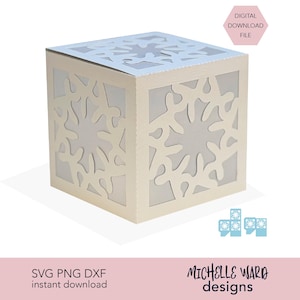 May include: A cream-colored, cube-shaped paper craft box with snowflake cutouts. The box has a light-colored interior, and the top is also cut with a snowflake design. Text on the image reads "DIGITAL DOWNLOAD FILE" and "SVG PNG DXF instant download".