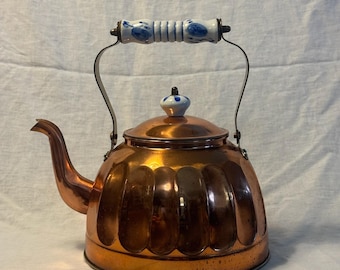 Tetera antigua de cobre con asa de porcelana de Delft.