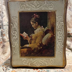 May include: A vintage wooden box with a white painted surface and gold trim. The box features an embossed floral design and a picture of a woman reading a book.