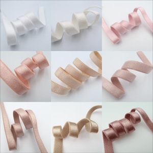 May include: Assortment of 10 yards of soft, elastic trim in various colors, including white, pink, beige, and gold. The trim is perfect for adding a touch of elegance to any project.