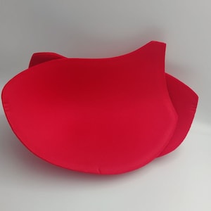 Puede incluir: Dos copas de sujetador de tela roja, diseñadas para agregar volumen y forma a un sujetador.