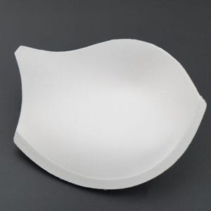 May include: White foam bra cup insert for adding volume and shape to a bra.