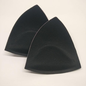 Puede incluir: Dos insertos de sujetador de forma triangular negra. Los insertos están hechos de un material suave y flexible y tienen una superficie lisa ligeramente texturizada.