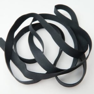 May include: Black elastic ribbon, approximately 1/2 inch wide, in a coiled shape.