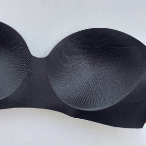 Puede incluir: Sujetador negro sin tirantes con copas moldeadas y un diseño liso y sin costuras.