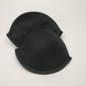 May include: Two black bra inserts made of foam, designed to add volume and shape to a bra cup.