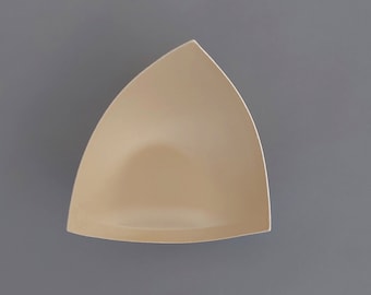 May include: A beige triangle-shaped bra insert made of foam.