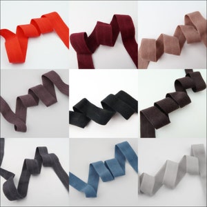 May include: Nine different colors of cotton ribbon, each folded in a loop. The colors are red, burgundy, light brown, dark brown, black, blue, gray, and two shades of brown.