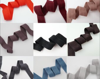 Puede incluir: Nueve cintas de algodón de diferentes colores, cada una doblada en un bucle. Los colores son rojo, burdeos, marrón claro, marrón oscuro, negro, azul, gris y dos tonos de marrón.