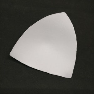 Puede incluir: Relleno de copa de sujetador blanco, una pieza triangular de tejido de espuma para usar en sujetadores.