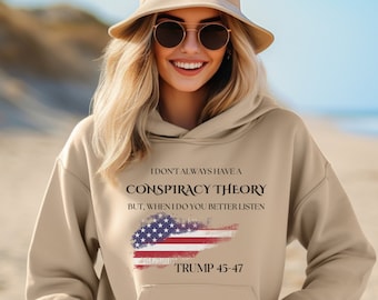 Könnte beinhalten: Beigefarbener Hoodie mit einem abgenutzten amerikanischen Flaggen-Motiv und dem Text "Ich habe nicht immer eine Verschwörungstheorie, aber wenn ich eine habe, solltest du besser zuhören. Trump 45-47".
