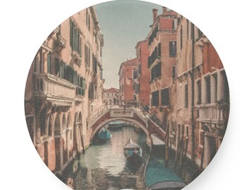 May include: A view of a narrow canal in Venice, Italy. The canal is lined with old buildings and there are several gondolas in the water. The buildings are a mix of red, orange, and yellow.