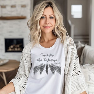 May include: White t-shirt with a black graphic that says "Forget the Village I Need the Whole Vineyard Mom Life". The graphic features a stylized image of a vineyard.