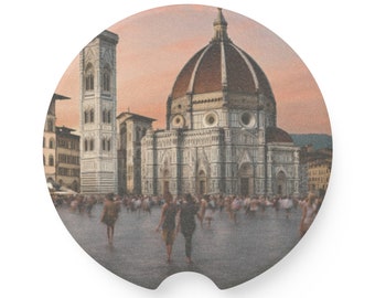May include: A vintage-style photo of the Duomo in Florence, Italy. The photo shows the iconic dome and facade of the cathedral, with a crowd of people in the foreground. The sky is a soft pink and orange, suggesting a sunset.