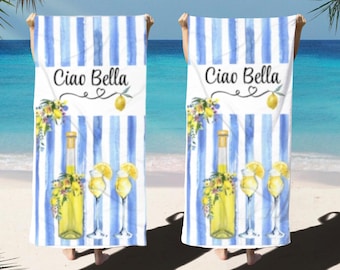 May include: Two beach towels with blue and white stripes. Each towel features a bottle of limoncello, two glasses of limoncello, lemons, and flowers. The text "Ciao Bella" is printed on each towel.