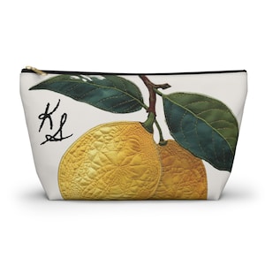 Puede incluir: Bolsa blanca con cremallera con una ilustración botánica de dos frutos amarillos, hojas verdes y un tallo marrón. La bolsa tiene las letras manuscritas "KS".