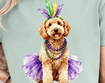 May include: A watercolor illustration of a poodle wearing a purple tutu, a beaded necklace, and a feathered headband. The dog has a light brown curly coat and is sitting upright. The image is on a light green t-shirt.