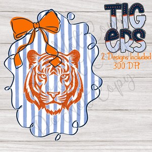 Op de afbeelding: Een digitaal ontwerp met een oranje glitter tijgergezicht op een blauw-wit gestreepte achtergrond, met een oranje strik. Het woord "Tigers" wordt weergegeven in een vet, gelaagd lettertype. Tekst bevat "2 Designs Included" en "300 DPI".