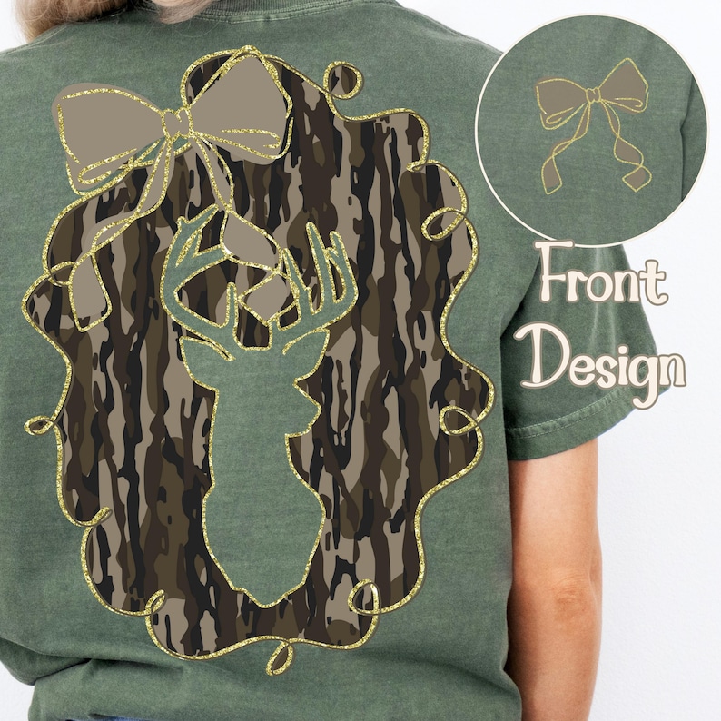 Puede incluir: Camiseta verde con una silueta de cabeza de ciervo en un dise&ntilde;o de camuflaje, enmarcada por un contorno dorado brillante y un lazo. Un dise&ntilde;o de lazo m&aacute;s peque&ntilde;o est&aacute; en la esquina superior derecha. Las palabras "Front Design" est&aacute;n impresas debajo.