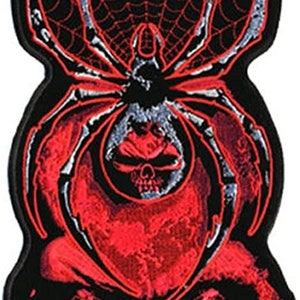 May include: A black and red embroidered patch featuring a skull with a spider web and spider on top. The spider is white and gray with red accents.