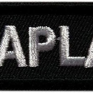 Peut inclure: Écusson brodé noir avec le mot "CHAPLAIN" en lettres blanches.