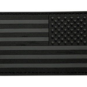 Può includere: Toppa della bandiera americana in bianco e nero con bordo cucito. La bandiera è realizzata in un materiale strutturato.