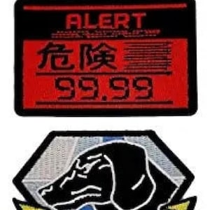 May include: A red and black patch with the text "ALERT" and "危険 99.99" in white. Below the patch is a gray and black diamond-shaped patch with a black dog head.