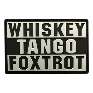 May include: Black and silver patch with the text "WHISKEY TANGO FOXTROT" in a military-style font.