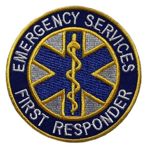 May include: A blue and gold embroidered patch with a star of life and a snake wrapped around a staff. The text reads "Emergency Services First Responder".