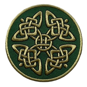 以下が含まれることがあります： 緑色の円形のワッペンで、金色のケルト結び目のデザインが施されています。結び目は複雑で細部まで作り込まれており、中央には四つ葉のクローバーの形をしています。
