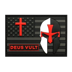 May include: A black and white patch with a red cross and a knight's helmet. The patch has the words "Deus Vult" in red letters on a black background. The patch is a symbol of the Knights Templar.