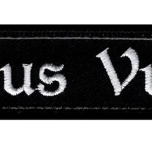 Può includere: Toppa ricamata nera con scritta bianca "Deus Vult".