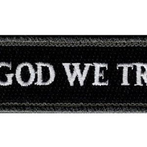 May include: Black embroidered patch with white stitching that reads "In God We Trust".