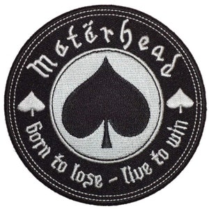 Może przedstawiać: Czarno-biała naszywka haftowana z tekstem "Megadeth" w stylu gotyckim, symbolem pika i tekstem "Born to lose - Live to win".