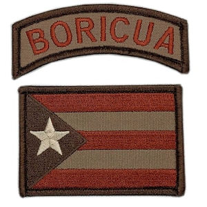 以下が含まれることがあります： 2つの刺繍パッチ。1つは茶色の背景に赤い文字で「BORICUA」と書かれており、もう1つは赤、白、茶色のプエルトリコの国旗が刺繍されています。