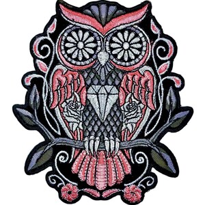 May include: Embroidered iron-on patch featuring a pink and black owl with a diamond on its chest, perched on a branch with roses and leaves.