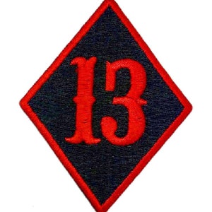 Könnte beinhalten: Rote gestickte Zahl "13" in einer schwarzen Raute.